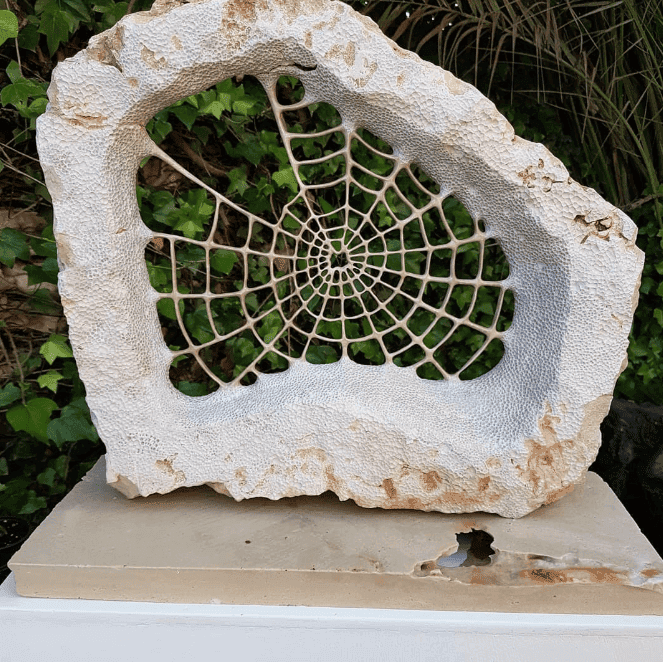 Escultura en piedra recreando una telaraña.