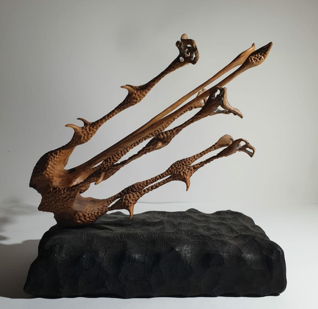 Side view of the sculpture where the tentacles and thorns on his arms can be seen.