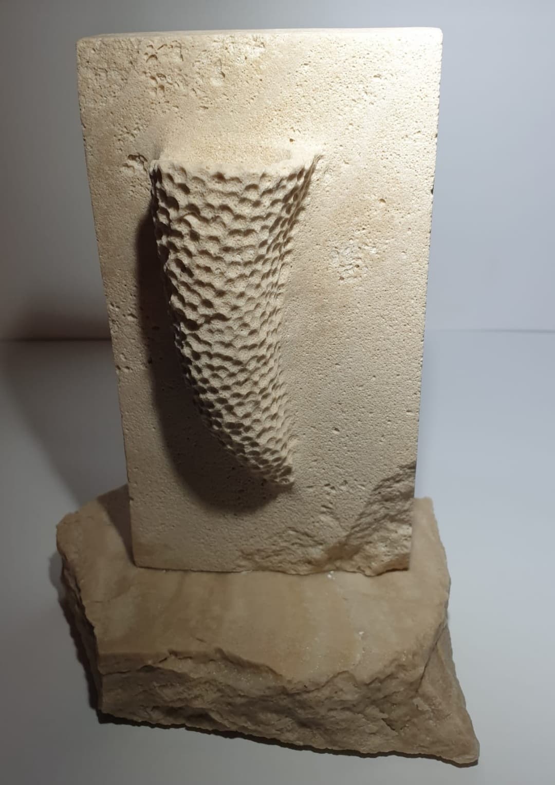 Vista frontal de la escultura "Esponja marina" sobre su base de piedra.