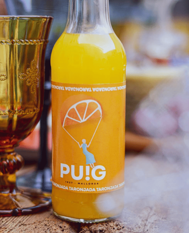 Botella de refresco de naranja encima de una mesa