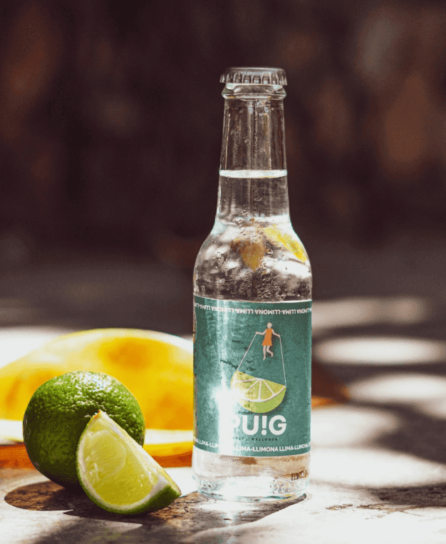 Refresco de lima-limón sobre mesa junto a frutas de lima