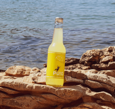 Refresco de limón sobre rocas y fondo de playa