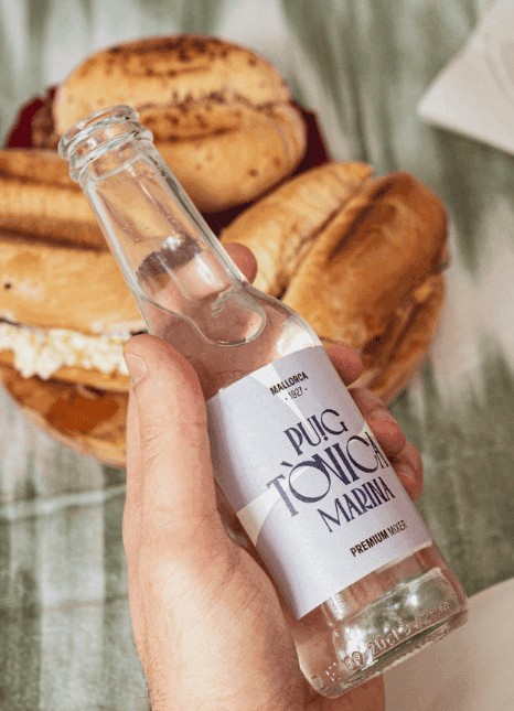Mano sujetando botella de tónica marina 