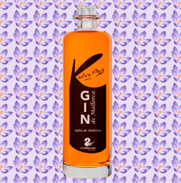 botella de ginebra premium por Koldo Royo sobre fondo de flores de azafrán