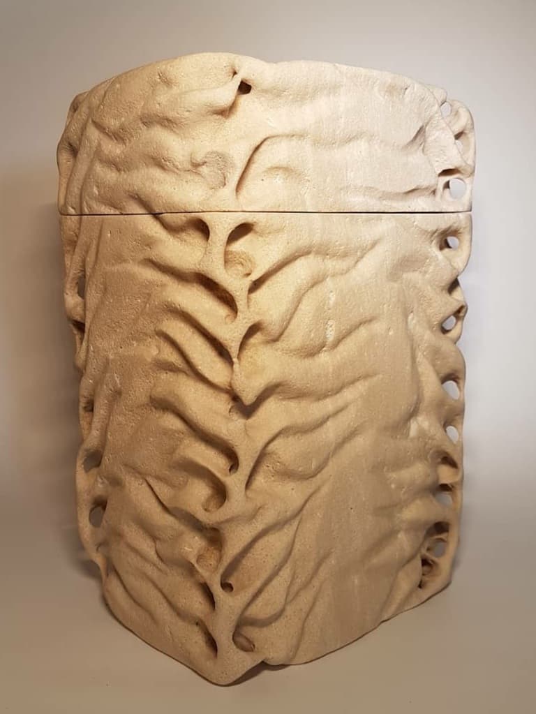 Sculpture of a funerary urn sculpted in stone from Santanyí. It has a wavy surface simulating the waves of life.