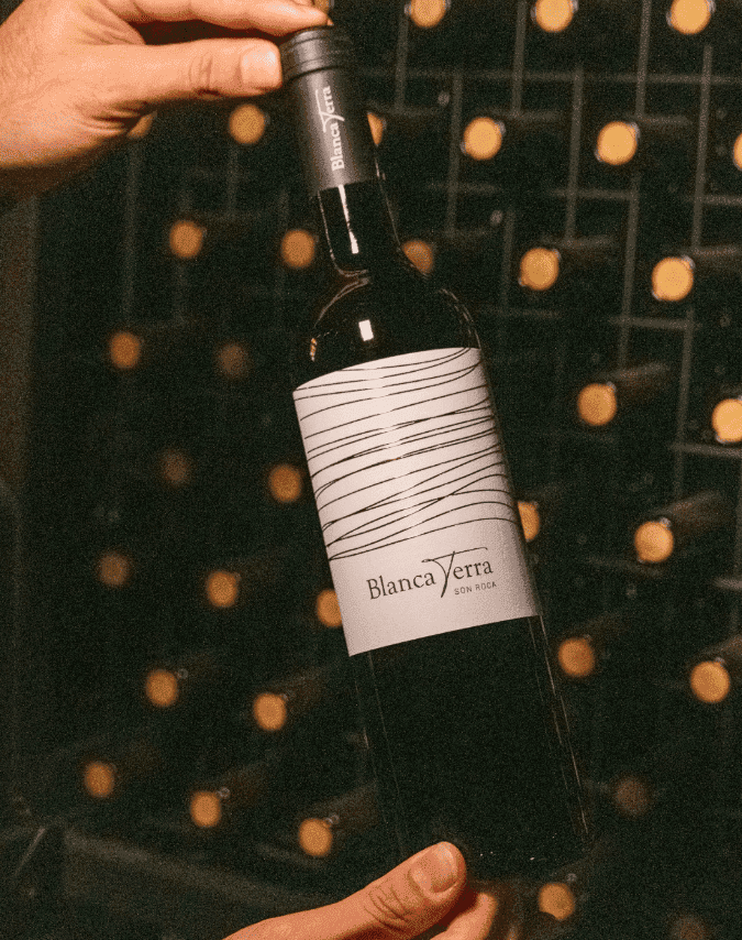 Hände halten Son Roca Weinflasche