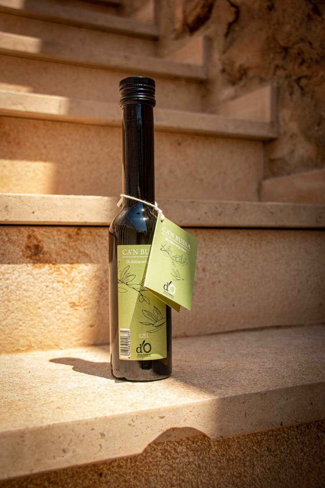 Botella de aceite de oliva virgen extra sobre escalera de pidra