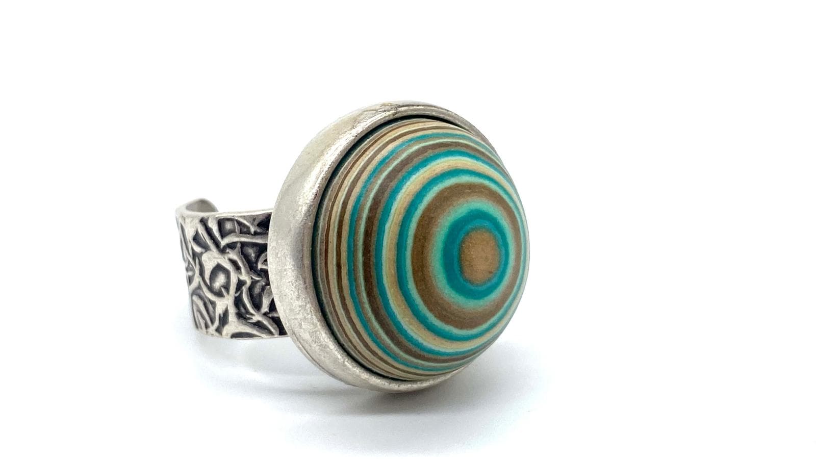 Imatge d'anell ull verd aigua sobre superfície blanca