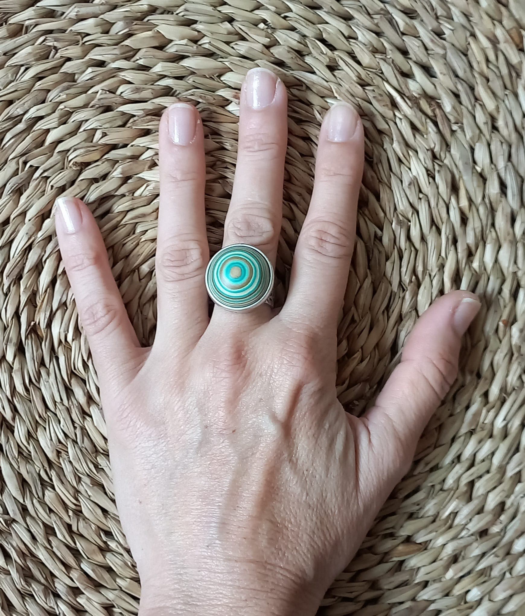 Imatge de mà sobre vímet amb anell ajustable verd aigua