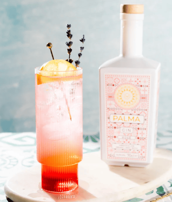 Botella de ginebra palmà rosé gin al costat de còctel elaborat amb aquesta ginebrar